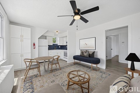 A living room with a ceiling fan and a rug on the floor.