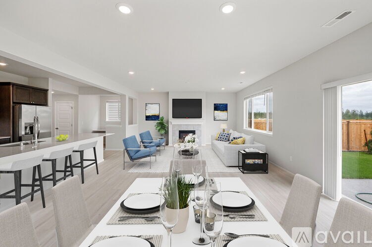 A modern dining room with a long table set for a meal.