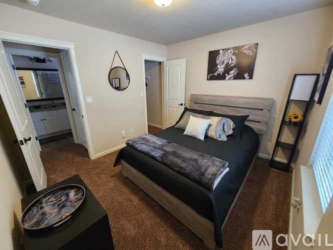A bedroom with a bed, a bench, and a mirror on the wall.