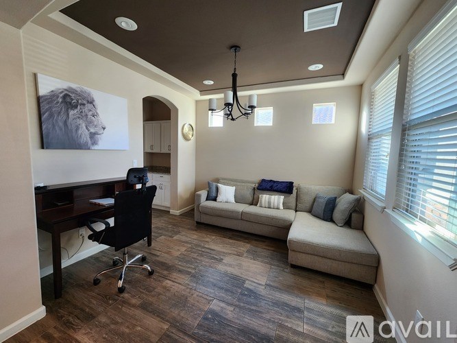 A room with a lion picture on the wall and a couch.