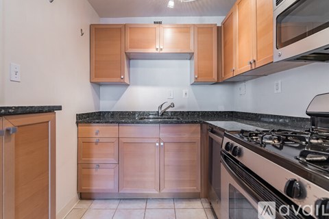 A kitchen with wooden cabinets and a black countertop.
