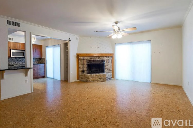 A living room with a fireplace and a ceiling fan.