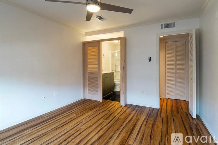 A room with wooden flooring and a ceiling fan.