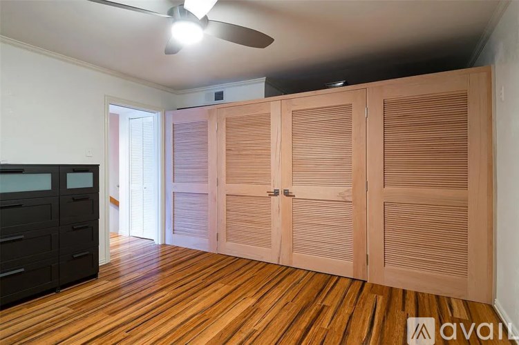 A room with wooden floors and a ceiling fan.