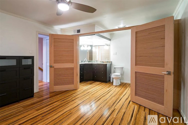 A room with wooden floors and a ceiling fan.