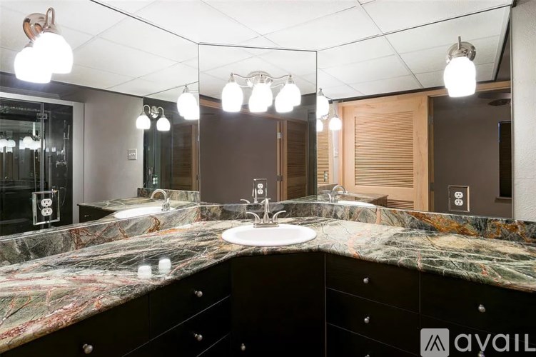 A bathroom with a marble countertop and a sink.