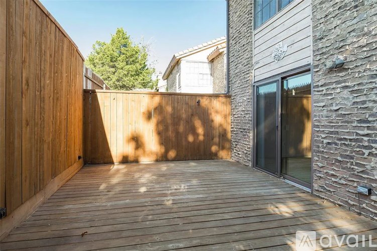 A wooden deck leads to a glass door.