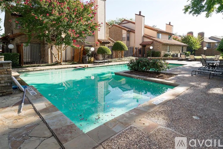 A pool surrounded by a patio and a fence.