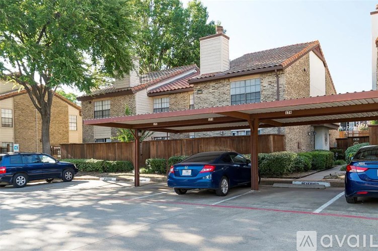 A parking lot with cars and a building in the background.