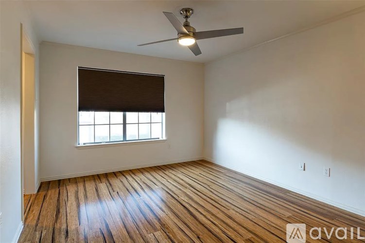 A room with wooden flooring and a ceiling fan.