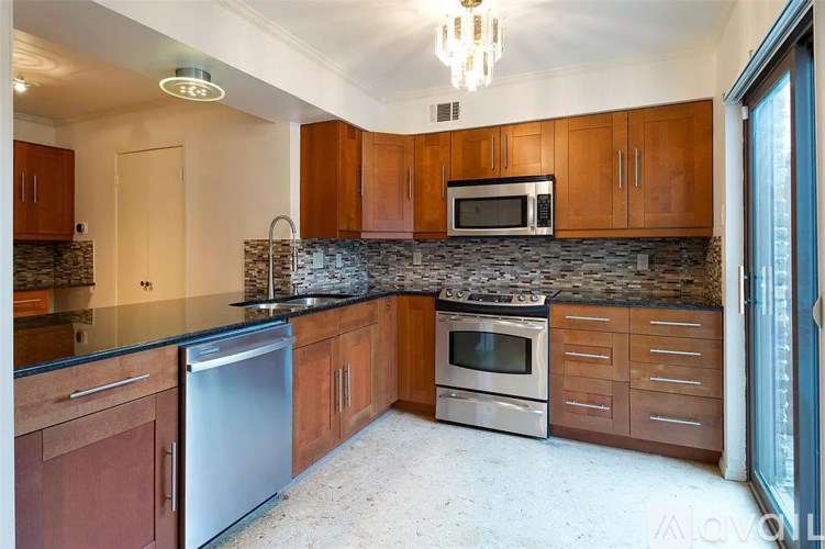 A kitchen with wooden cabinets and a stone backsplash.