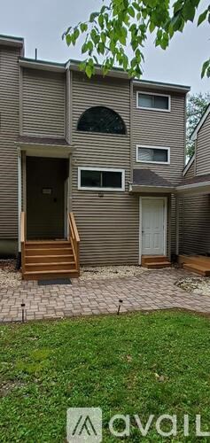 A two-story house with a front porch and a small garden.