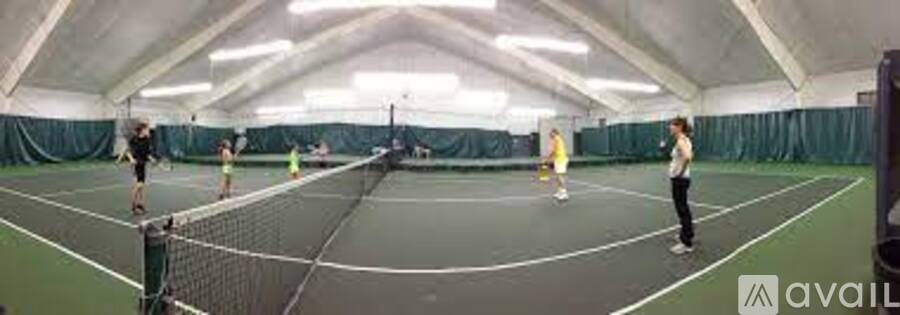 A group of people playing tennis in an indoor court.