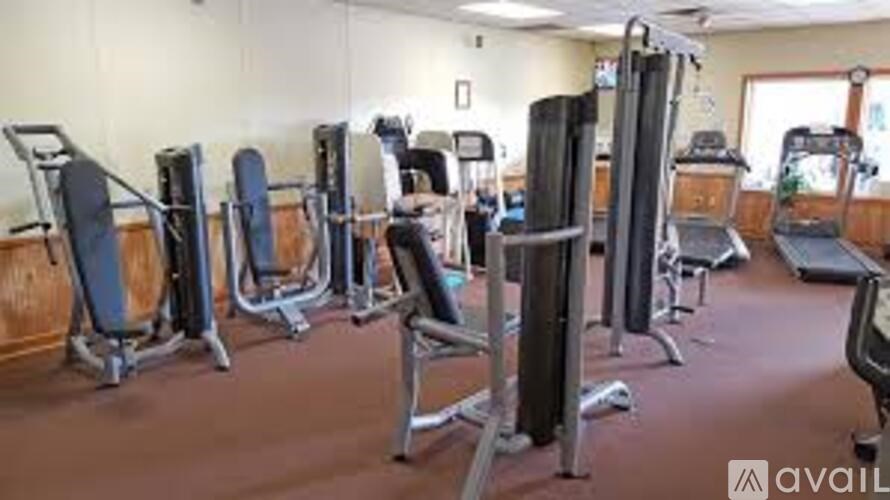 A gym with a variety of equipment including treadmills, weights, and exercise machines.