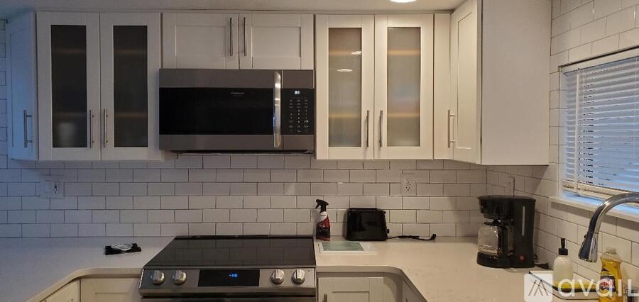 A kitchen with a stove top oven and a microwave above it.