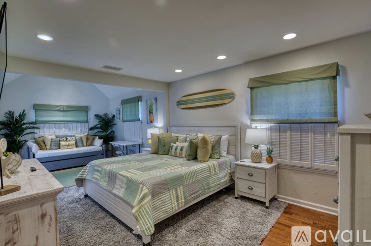 A bedroom with a bed and a nightstand with a lamp.
