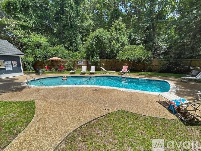 A backyard with a pool and a small building.