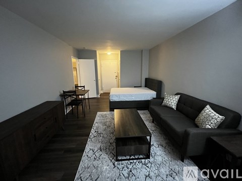 A living room with a black couch and a coffee table.
