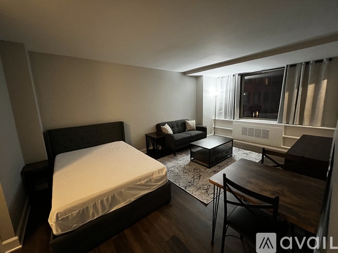 A bedroom with a bed, couch, and table.