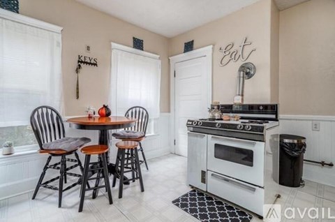 A kitchen with a table and chairs and a stove top oven.