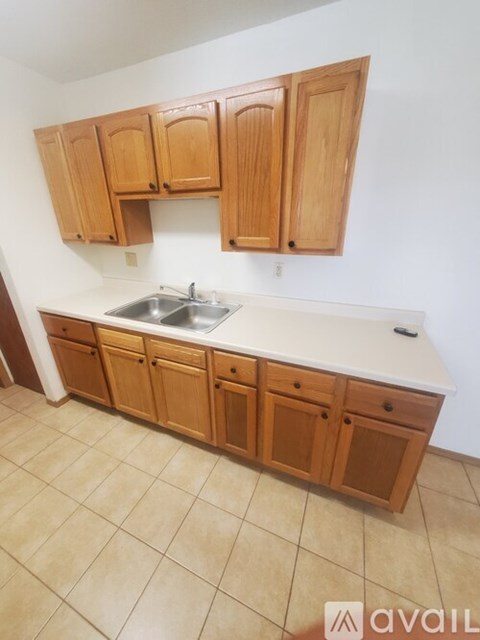 A kitchen with wooden cabinets and a white countertop.