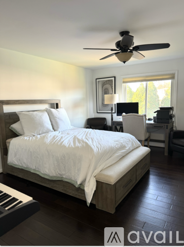 A bedroom with a large bed and a ceiling fan.