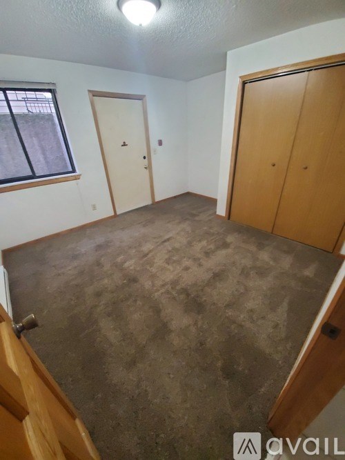 A room with a concrete floor and wooden doors.