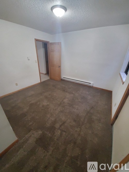 A room with a brown floor and a brown door.