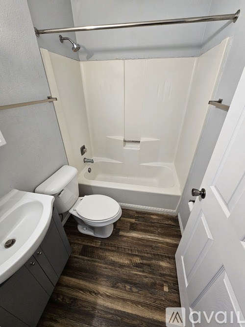A white toilet sits in a bathroom next to a bathtub.