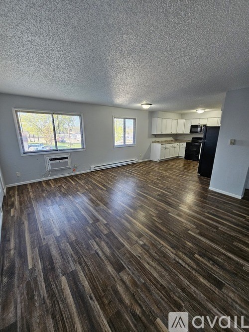 A kitchen with black appliances and white cabinets.