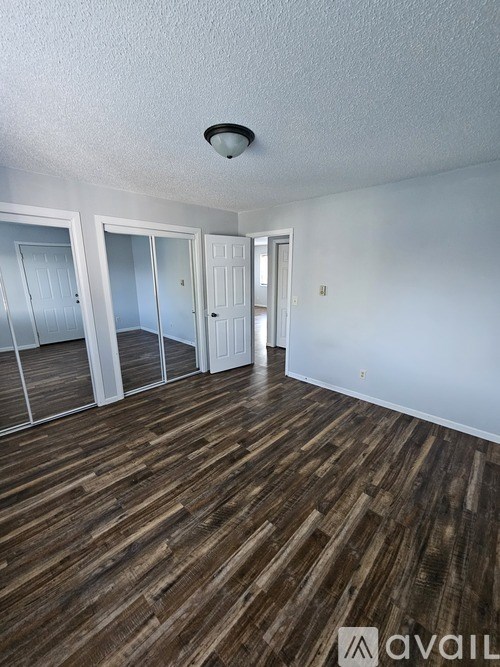 A room with two wooden doors and a washing machine in the background.