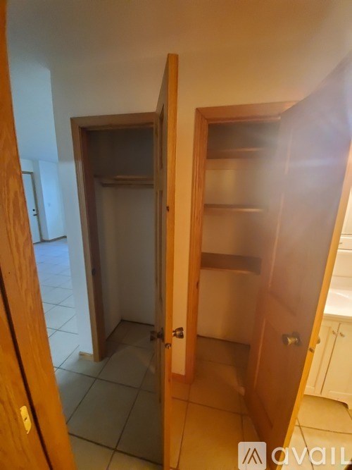 A hallway with a door on the left and a closet on the right.
