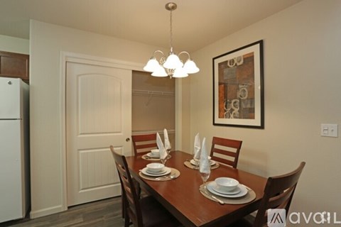 A dining room with a wooden table set for four.