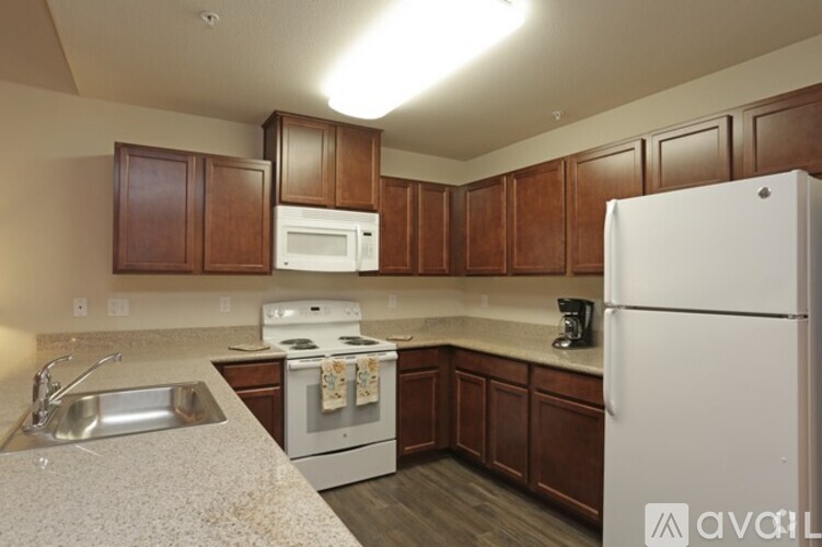 A kitchen with a white refrigerator, white microwave, and white stove.