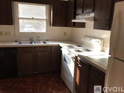 A kitchen with a white stove top oven and a white refrigerator.