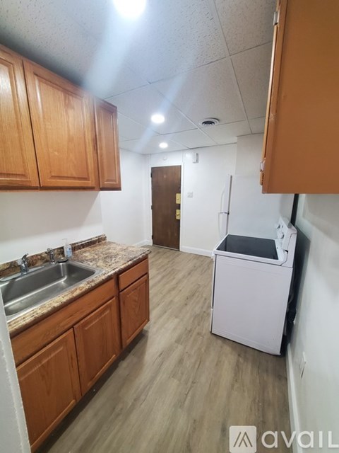 A kitchen with wooden cabinets and a white dishwasher.
