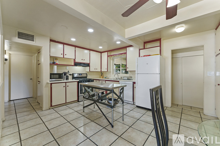 A kitchen with a table and chairs in the middle.