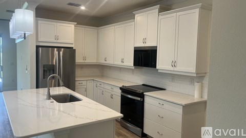 A kitchen with white cabinets and a sink.