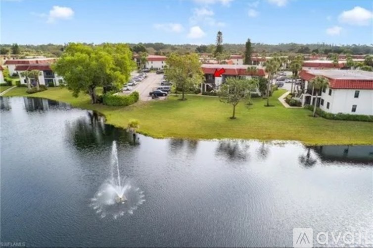 A fountain in the middle of a lake surrounded by buildings.