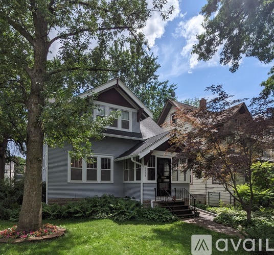 A house with a front yard and a tree in the front.