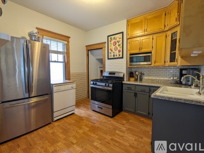 A kitchen with wooden cabinets and a refrigerator.