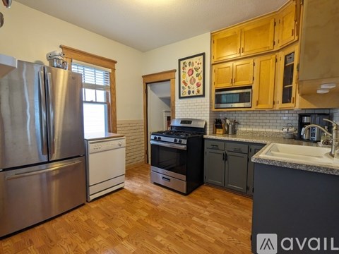 A kitchen with wooden cabinets and a refrigerator.