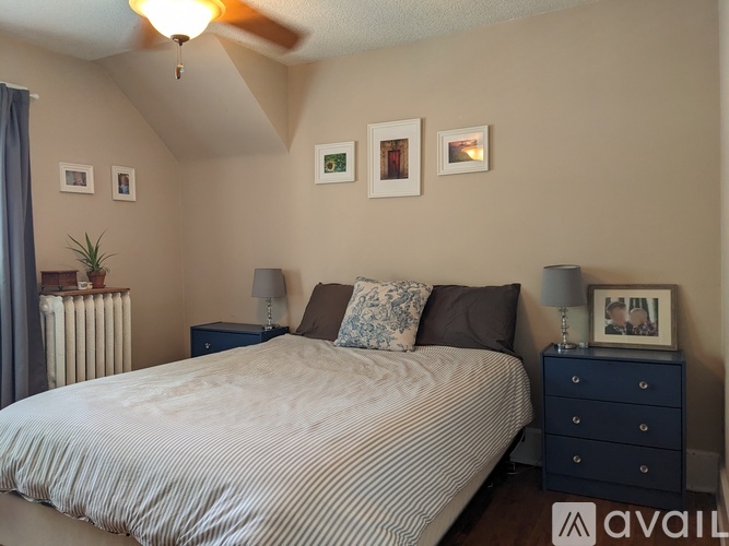 A bedroom with a bed, nightstand, and a ceiling fan.
