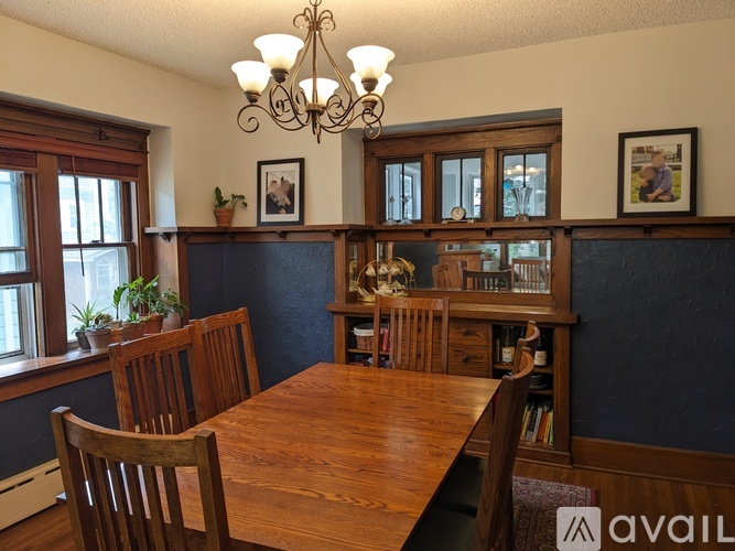 A dining room with a wooden table and chairs.