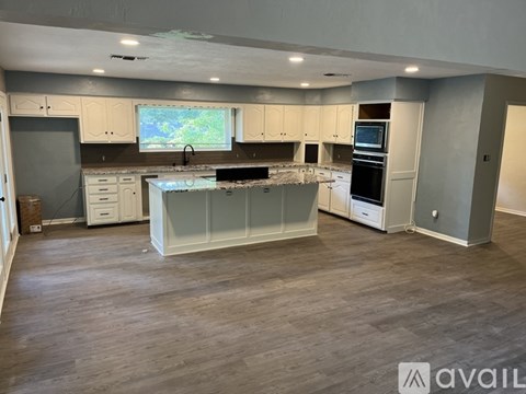 A spacious kitchen with white cabinets and a large island.