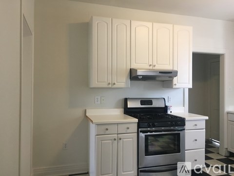 A kitchen with white cabinets and a stove top oven.