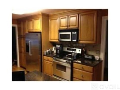 A kitchen with wooden cabinets and stainless steel appliances.