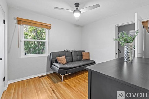 A living room with a grey couch and a wooden floor.