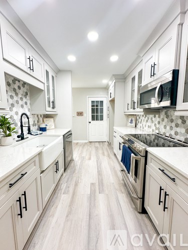 A kitchen with white cabinets and a tiled backsplash.
