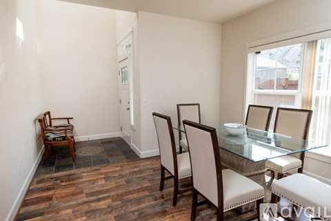 A dining room with a glass table and chairs.